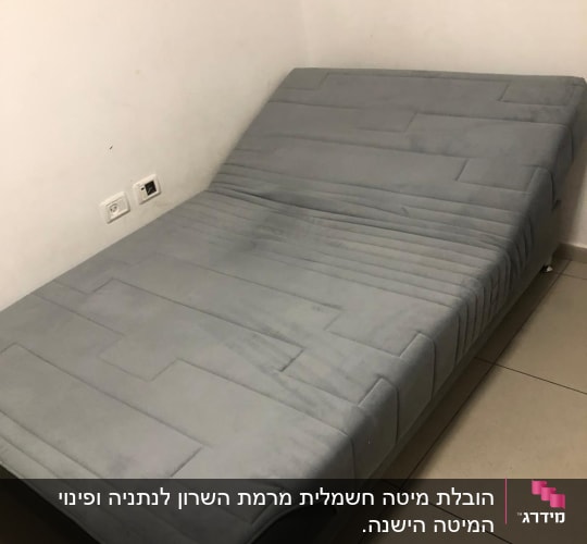 מיטה אפורה עם מזרן מרופד בחדר קטן